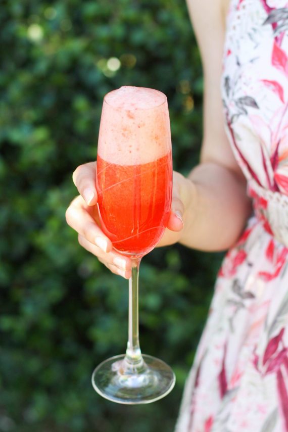 Woman holding low FODMAP strawberry mimosa-2