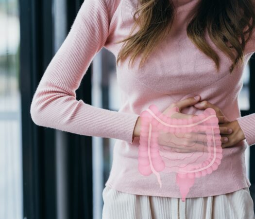 Woman clutching gut experiencing constipation overflow