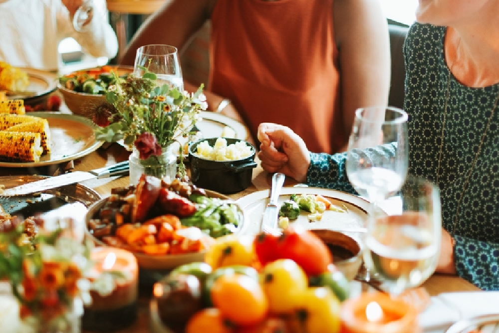 People enjoying a shared meal together, illustrating the long-term goal of the low FODMAP diet to confidently enjoy a wide variety of foods.