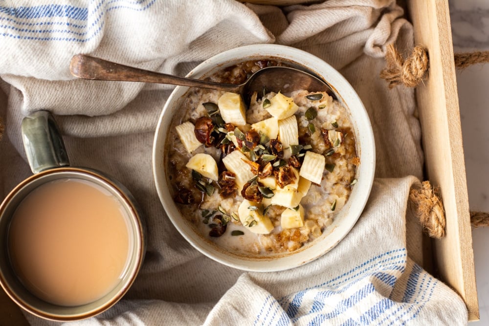 Bowl of low FODMAP porridge with banana, seeds and dates